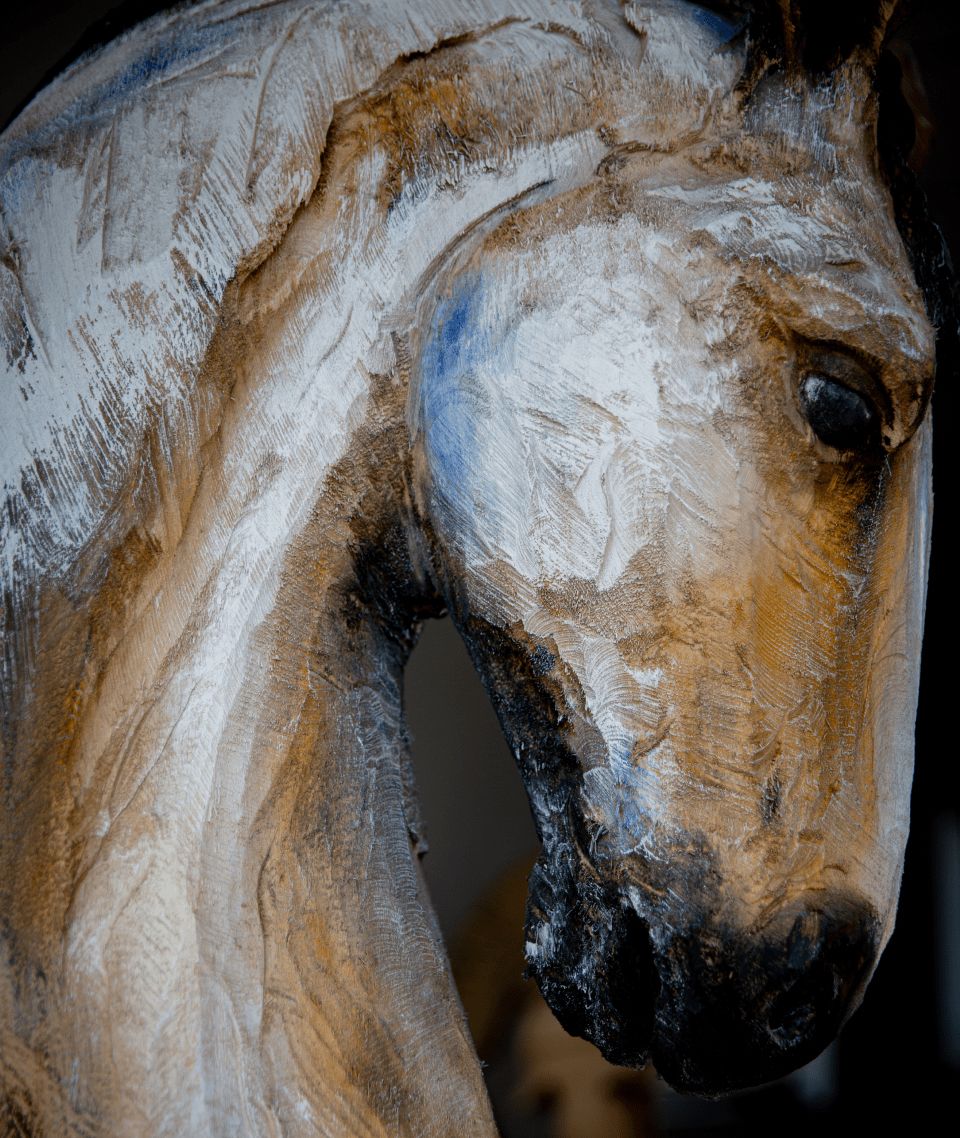 Nahaufnahme einer abstrakten Pferdeskulptur mit strukturierten Strichen in Weiß und Braun.